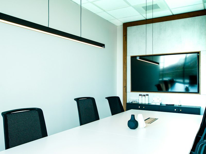 Meeting room with a white table and a wall-mounted display