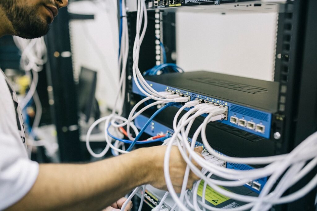 Engineer terminating network cables in a rack